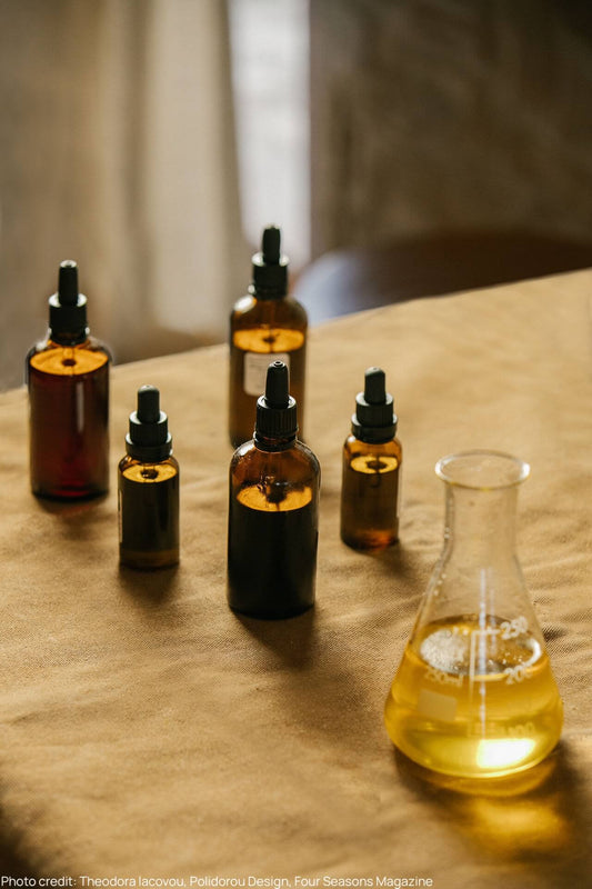 Liven cyprus essential oils in amber glass bottles against a linen surface