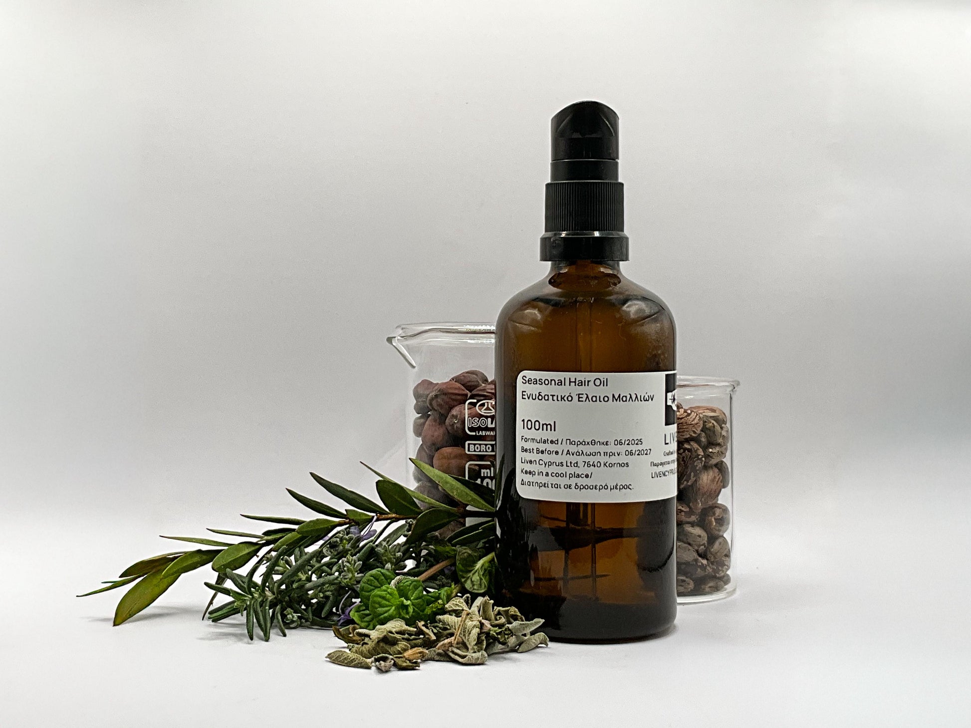 Brown glass bottle with a label on a white background, surrounded by dried herbs and plants.