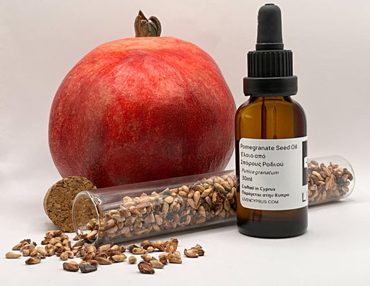 Pomegranate seed oil bottle with pomegranate and seeds on a light background