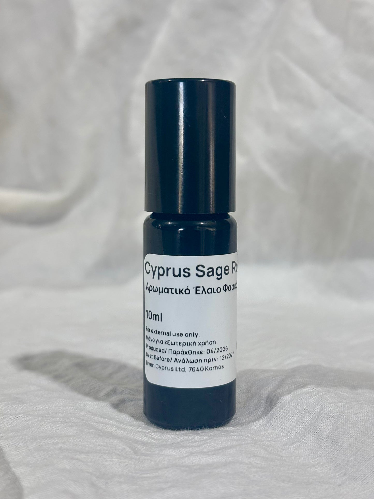 Roll-on bottle labeled 'Cyprus Sage' on a textured white background
