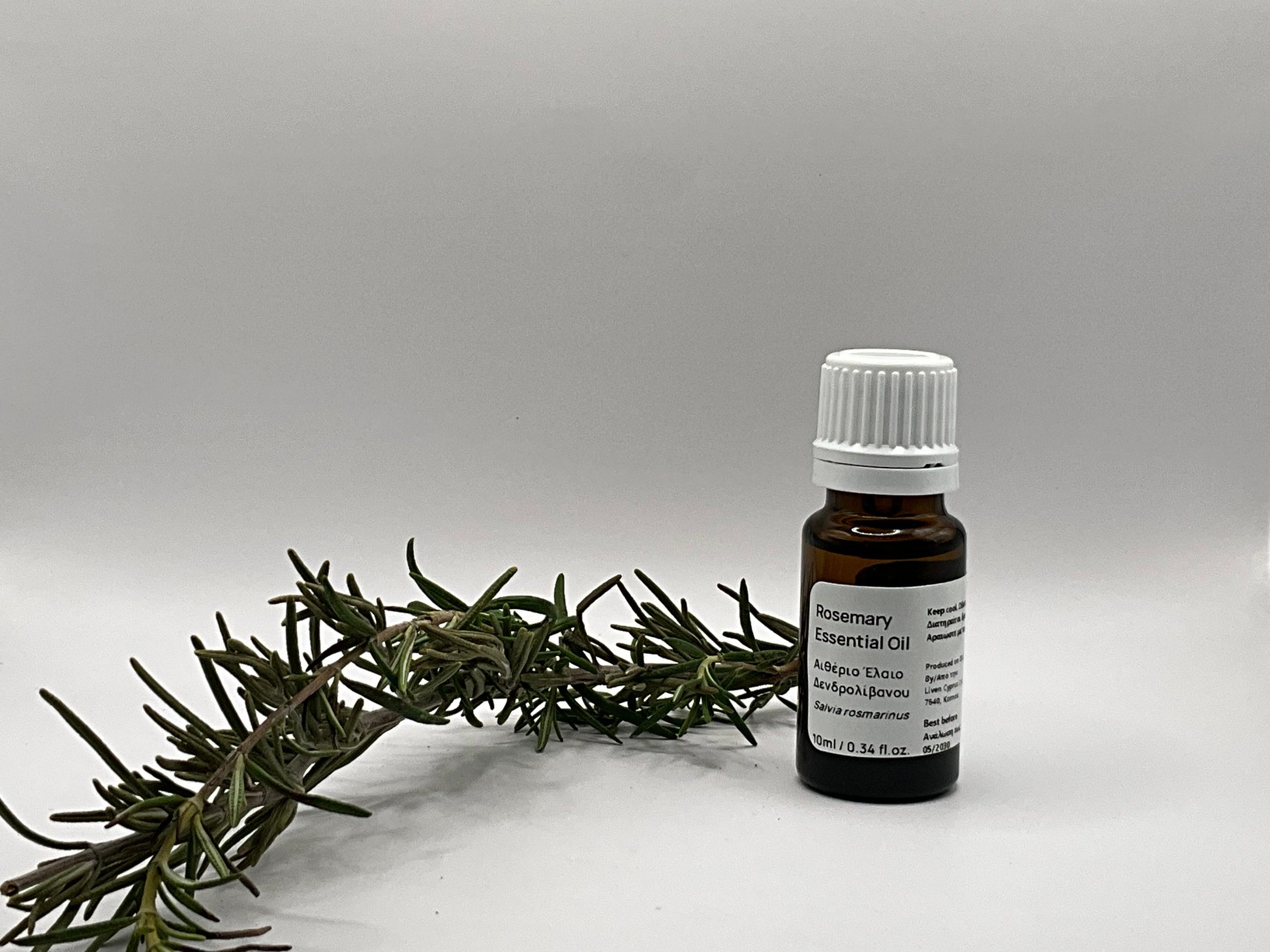 rosemary oil  bottle next to plant