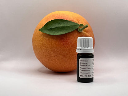 Bottle of essential oil next to a cyprus grapefruit