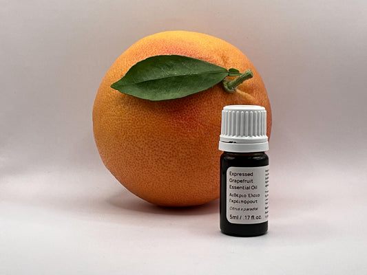 Bottle of essential oil next to a cyprus grapefruit
