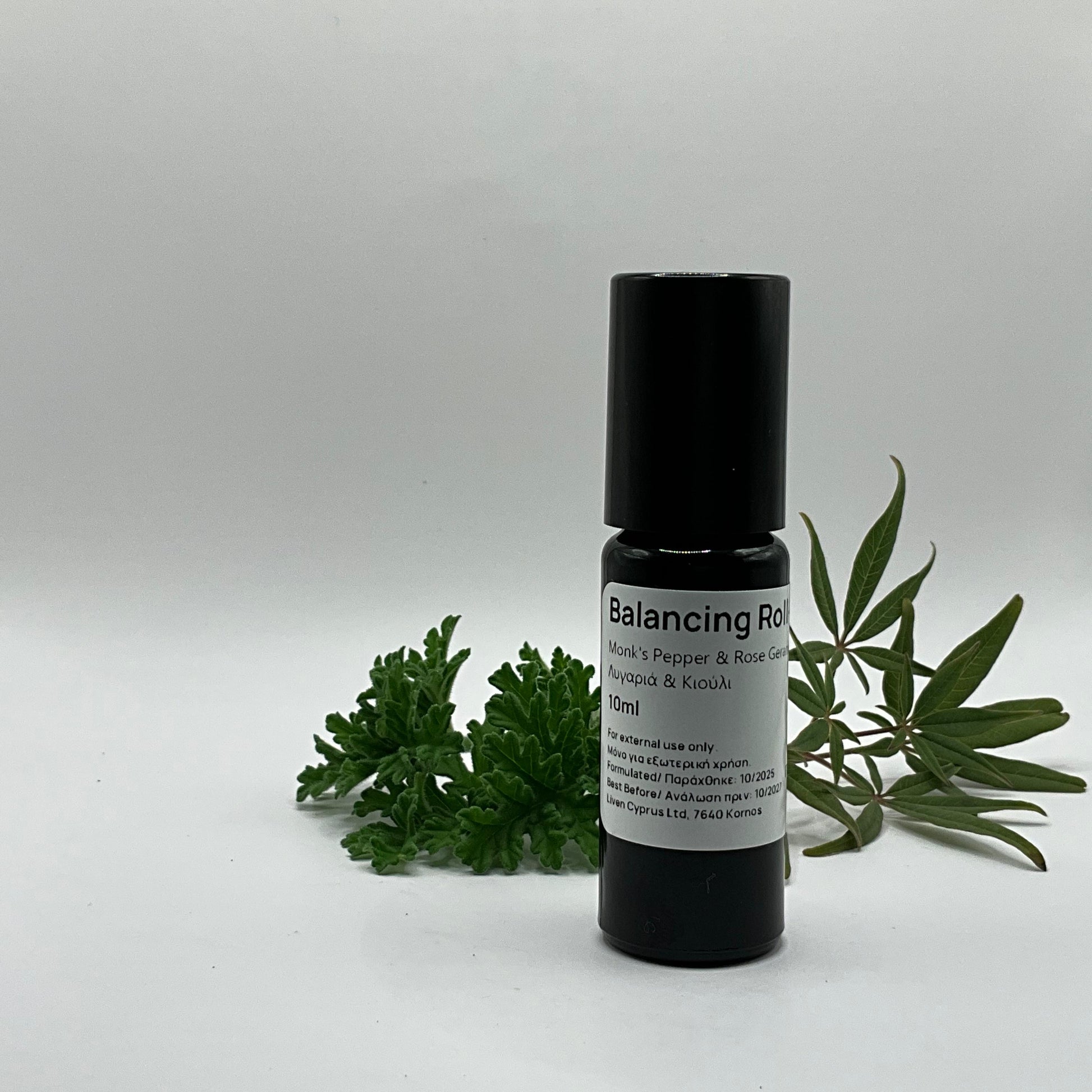 Black roller bottle labeled 'Balancing Roll' with green leaves on a light gray background
